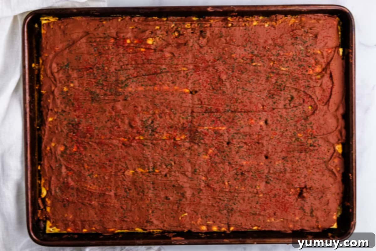 Yuletide Toffee Obsession 12 christmas crack toffee topped with red and green sprinkles on a baking sheet.