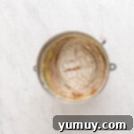 Golden Cinnamon Bundt Cake 13 dry ingredients mixed into wet ingredients in a stainless steel bowl.