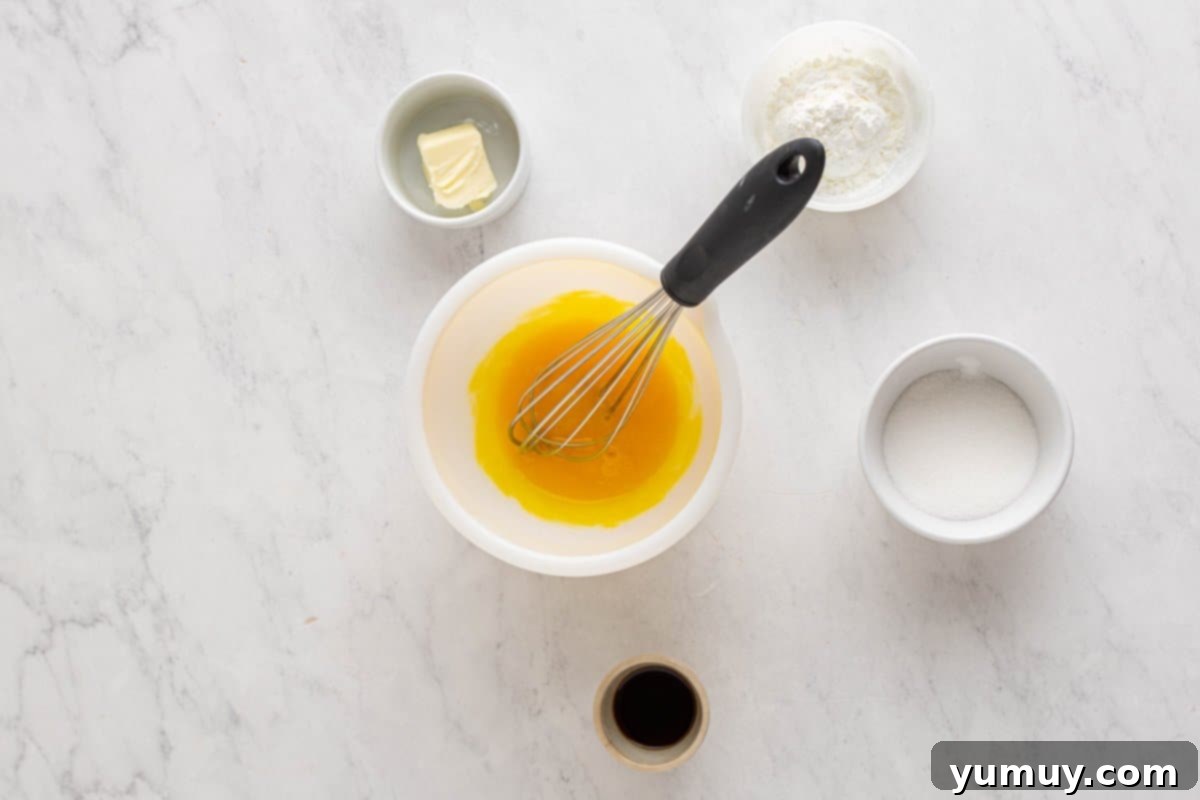 Golden Cinnamon Bundt Cake 21 whisked egg yolks in a white bowl with a whisk.