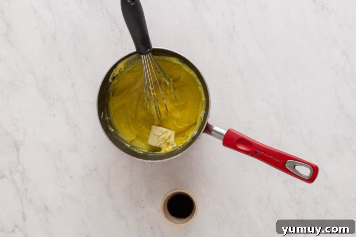 Golden Cinnamon Bundt Cake 24 custard mixture being whisked in a saucepan with a whisk.