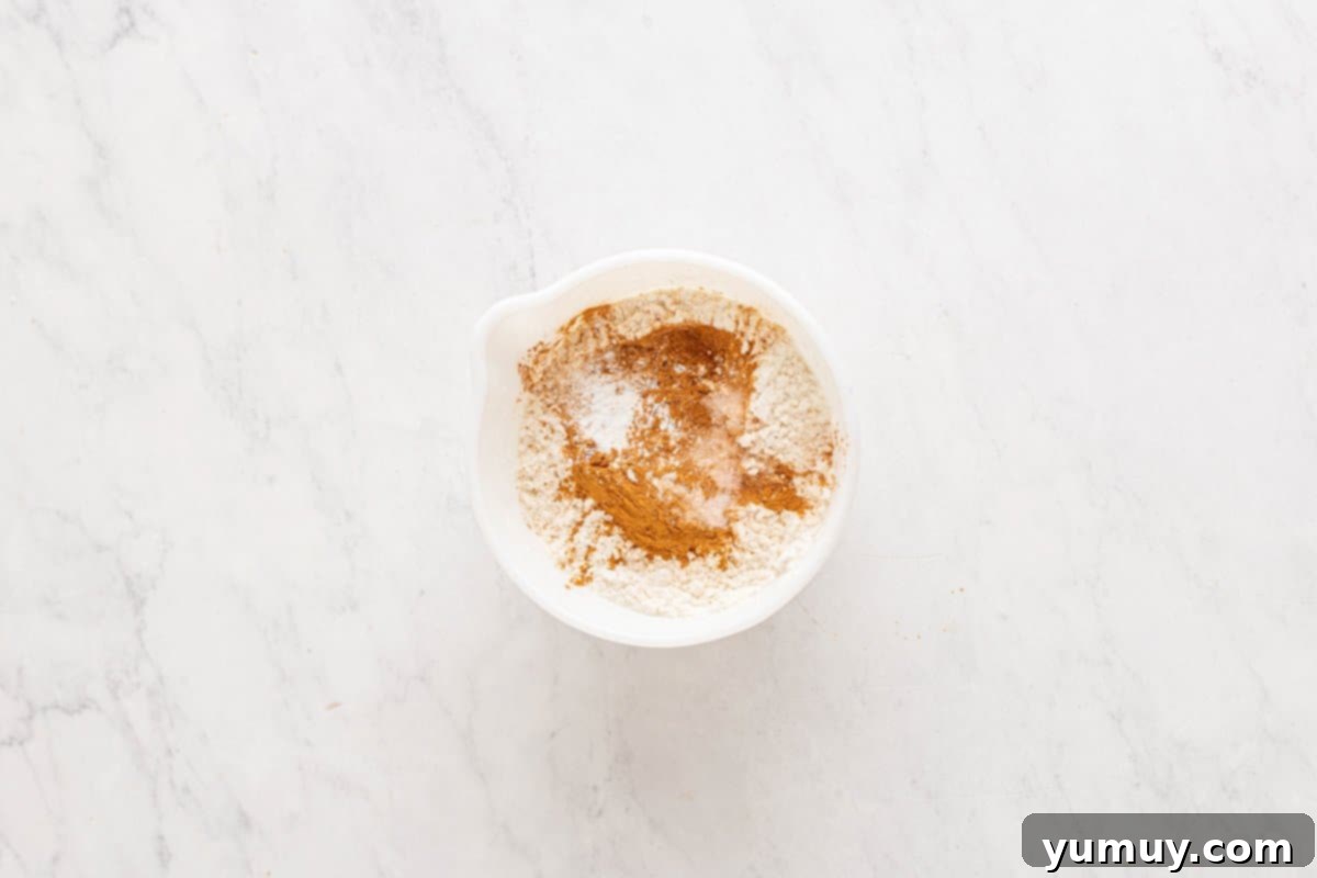 Golden Cinnamon Bundt Cake 25 dry ingredients for churro bundt cake in a white bowl.