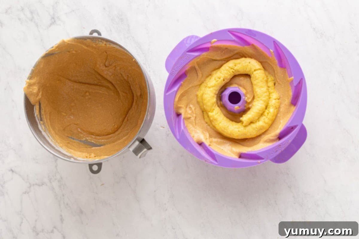 Golden Cinnamon Bundt Cake 30 custard filling piped on top of bundt batter in a purple silicone bundt mould.