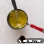 Golden Cinnamon Bundt Cake 9 custard mixture being whisked in a saucepan with a whisk.