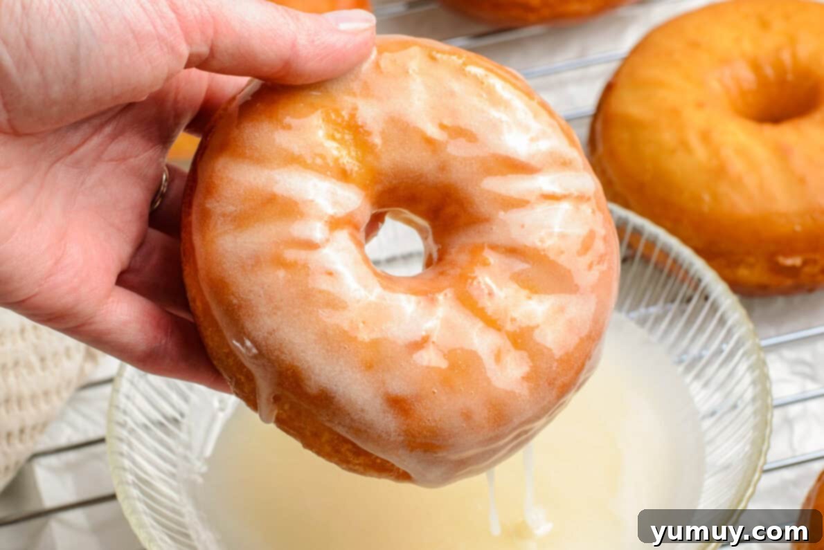 Homemade Krispy Kreme Glazed Donuts 18 dipping donut into glaze
