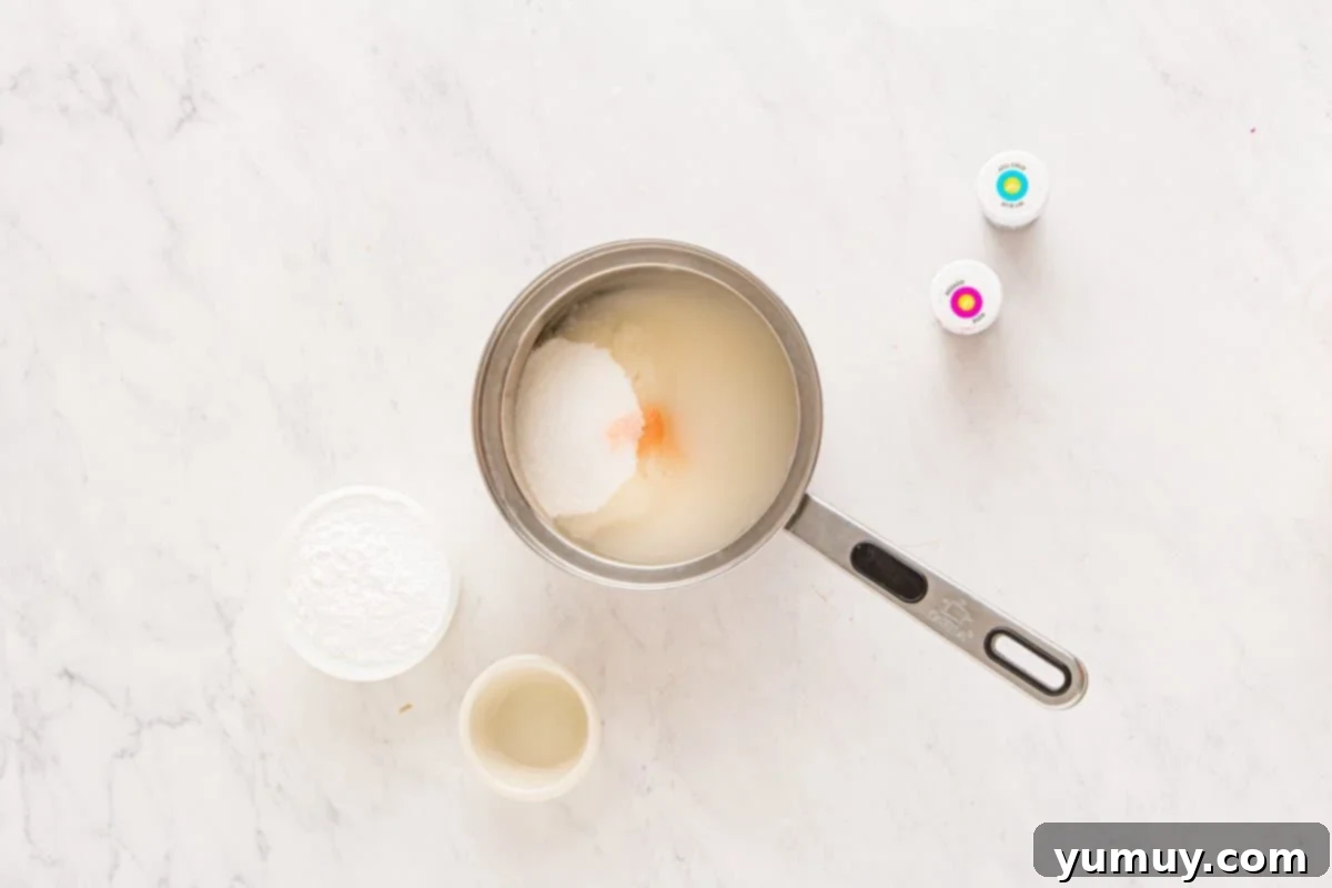 Spun Sugar Pillows 12 A saucepan filled with ingredients for cotton candy marshmallows, including sugar, corn syrup, and water, simmering on a stove.