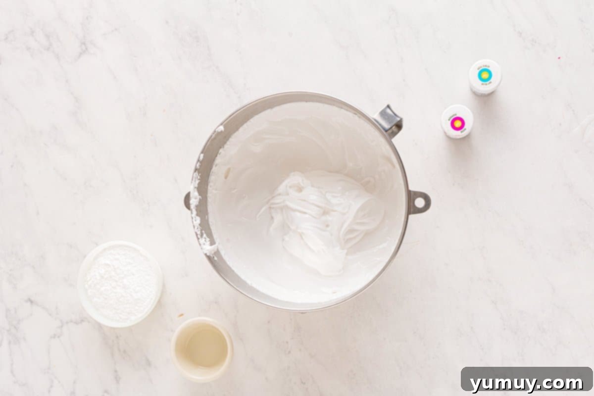 Spun Sugar Pillows 13 A stand mixer bowl filled with a fluffy, whipped marshmallow mixture, ready to be flavored and colored.