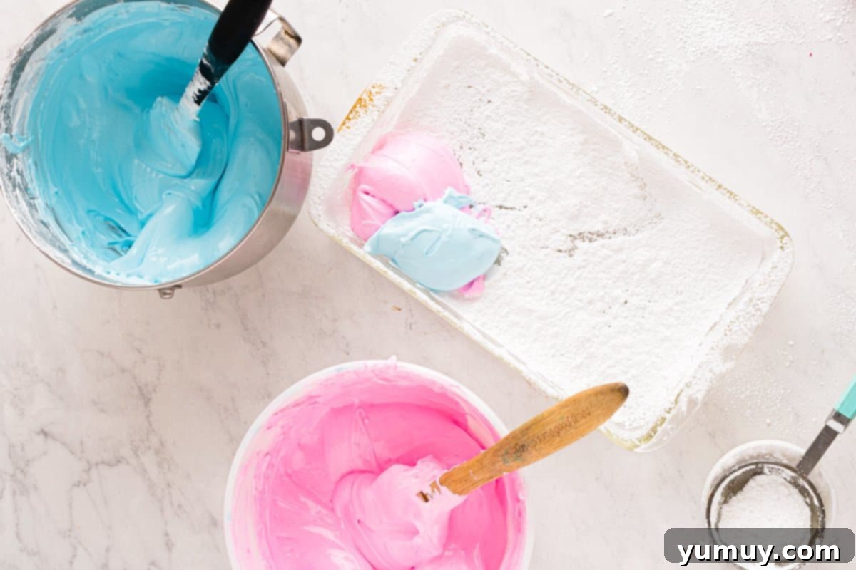 Spun Sugar Pillows 14 Pink and blue marshmallow mixtures being alternately spooned into a white rectangular baking pan for a marbled effect.