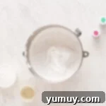 Spun Sugar Pillows 7 Fluffy, whipped marshmallow mixture swirling in a stainless steel mixing bowl, ready for flavoring.