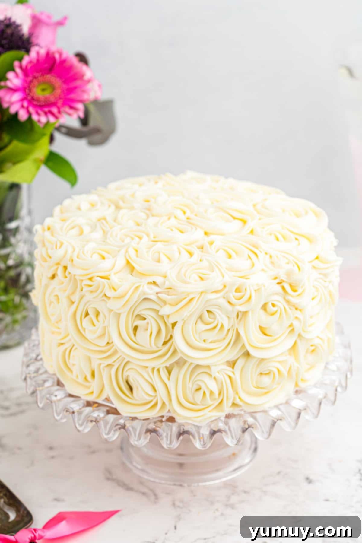 Beautifully decorated easy homemade wedding cake on a sophisticated glass cake stand, ready to be served.