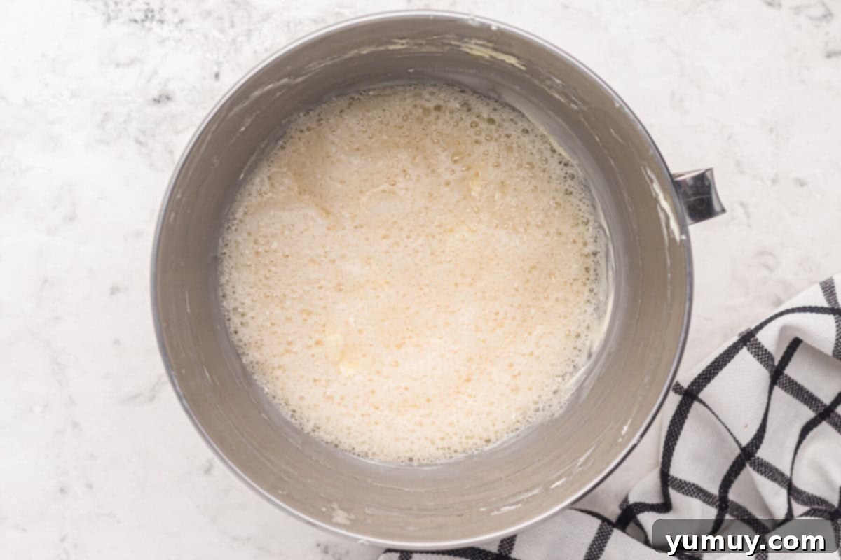 Foamy egg mixture for easy homemade wedding cake, lightly whisked in a stainless steel mixing bowl, showing the ideal slightly aerated consistency.