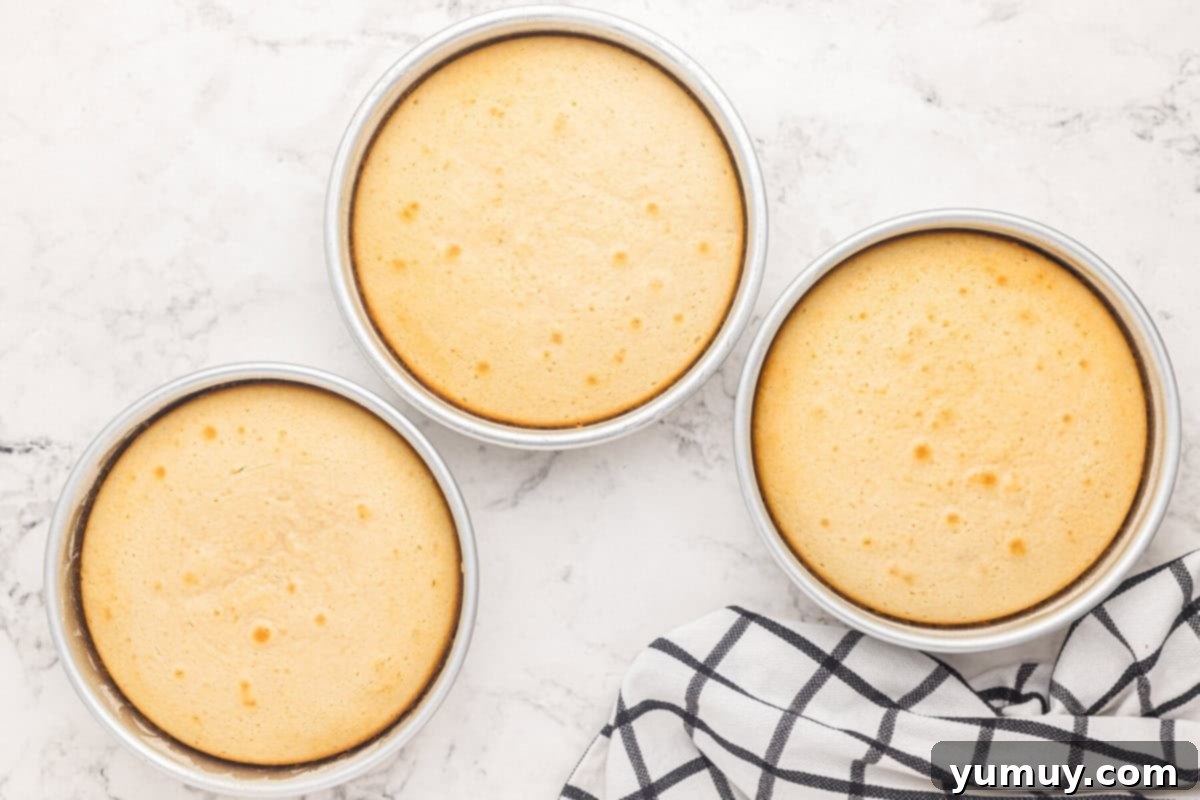 Three golden-baked pans of easy homemade wedding cake, fresh from the oven and cooling on a wire rack.