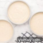 Easy homemade wedding cake batter is perfectly divided among three round cake pans, ready for baking.