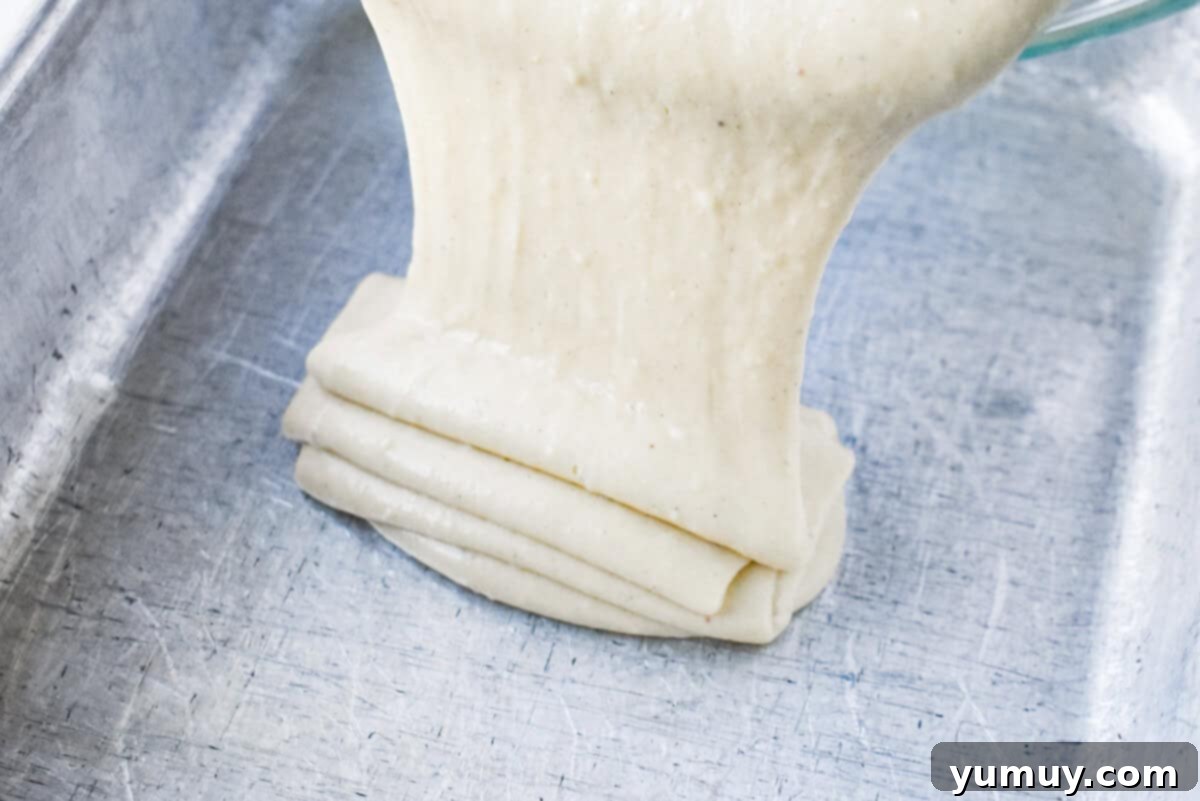 Smooth eggnog sheet cake batter, freshly poured into a greased 9x13 inch baking pan, poised for baking.