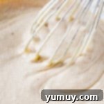 eggnog sheet cake batter in a glass bowl with a whisk.