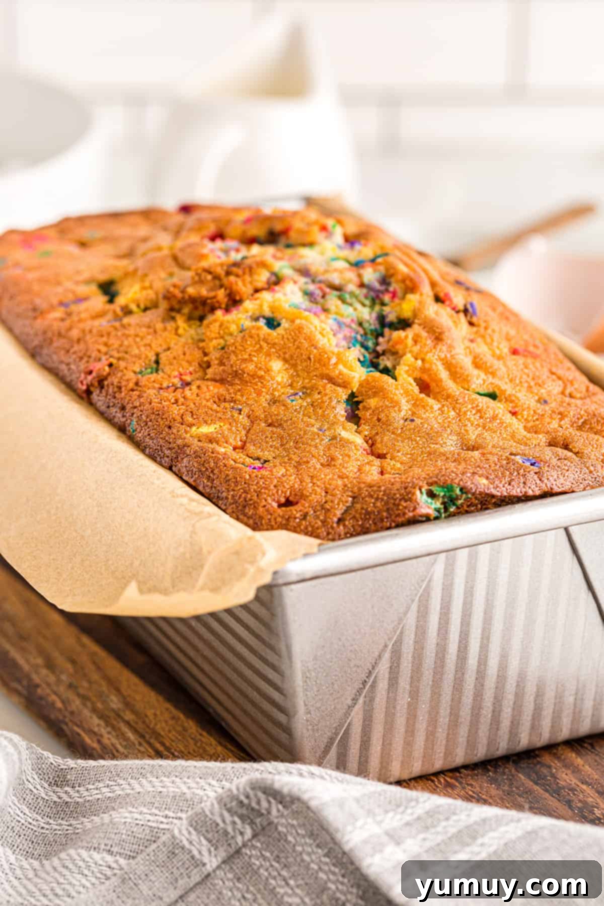 Baked funfetti pound cake cooling in a loaf pan, showcasing its golden-brown crust.