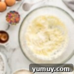 Creamed butter and sugar in a glass mixing bowl, light and fluffy.