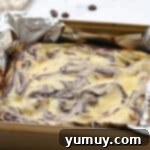 freshly baked cream cheese brownies in a foil-lined baking pan.