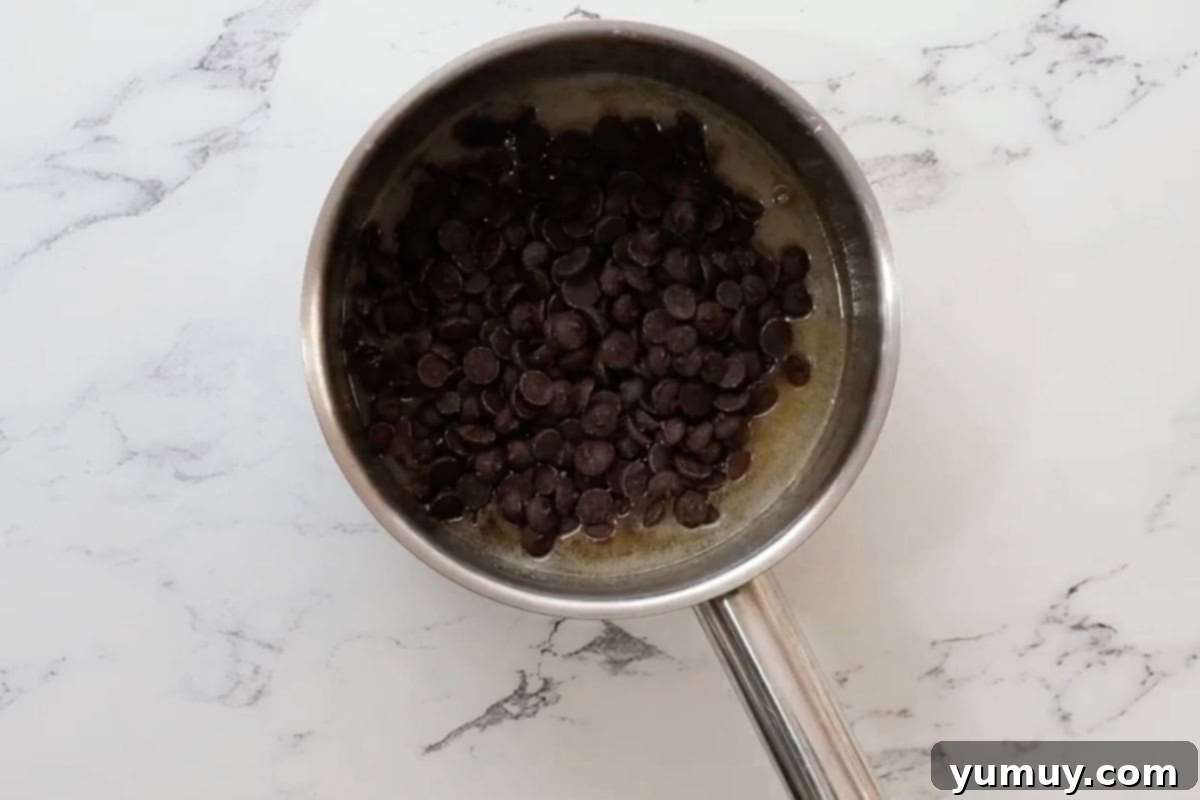 adding chocolate chips to melted butter in a saucepan.