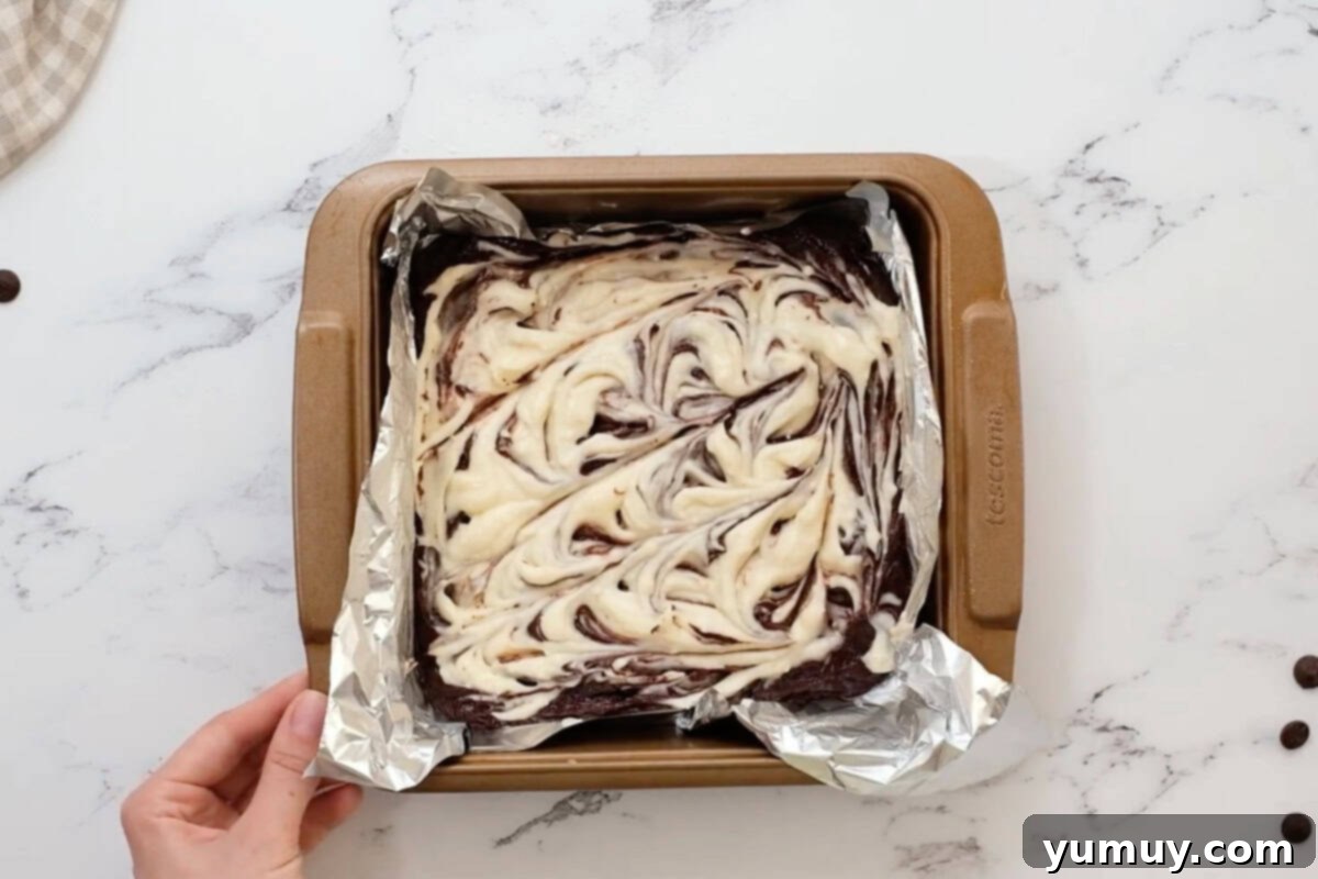 cream cheese swirl brownies in a foil-lined baking pan before baking.