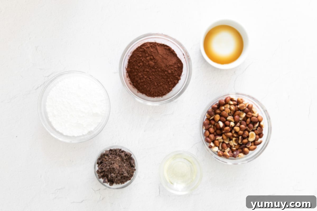 Velvety Homemade Chocolate Hazelnut Spread 8 Small bowls containing the essential ingredients for homemade Nutella: raw hazelnuts, powdered sugar, cocoa powder, and chopped chocolate, ready to be combined.