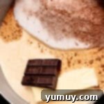 Decadent Chocolate Fudge Sauce 6 A chocolate bar, a stick of butter, and evaporated milk wait to be combined with dry ingredients in a saucepan, ready for the homemade hot fudge cooking process.