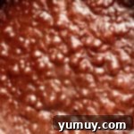 Decadent Chocolate Fudge Sauce 7 Hot fudge sauce bubbling in a pan on the stove, indicating it's almost ready to be removed and cooled, showcasing its rich, dark color and smooth texture.