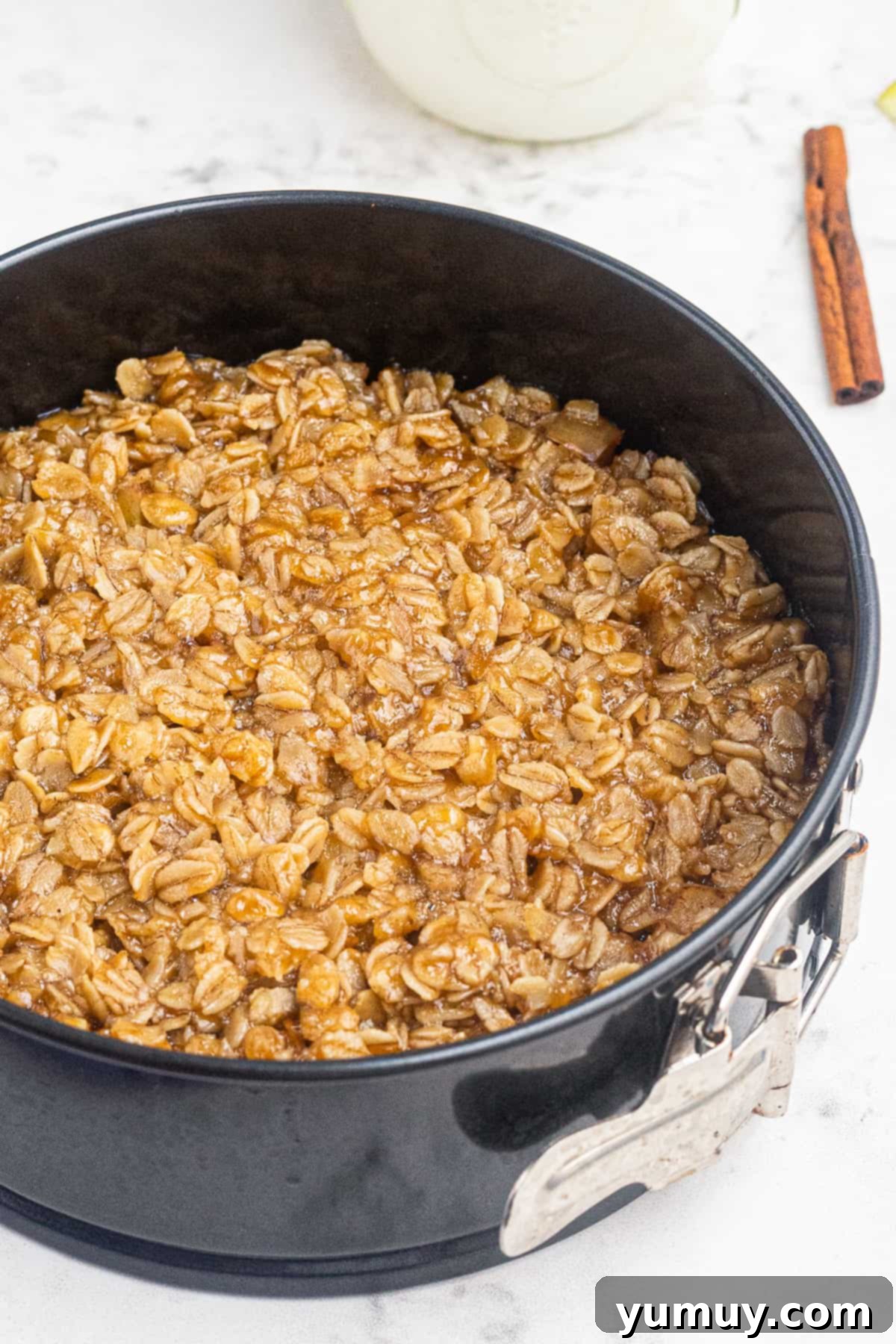 Up close view of a warm Instant Pot apple crisp in a baking pan, showing the golden oat topping and soft apple filling.