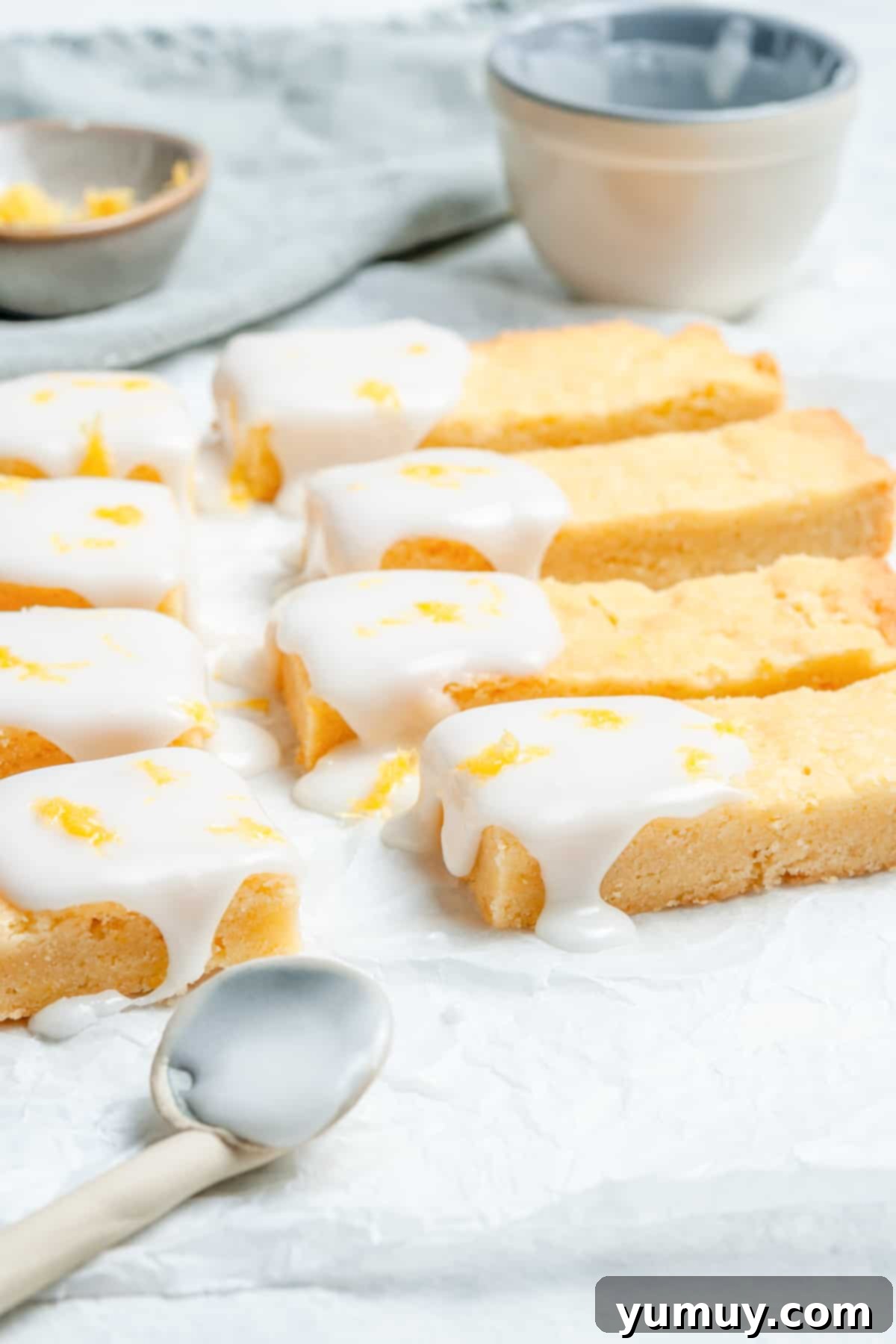 Lemon shortbread cookies, elegantly iced on one end, arranged beautifully on a serving dish.
