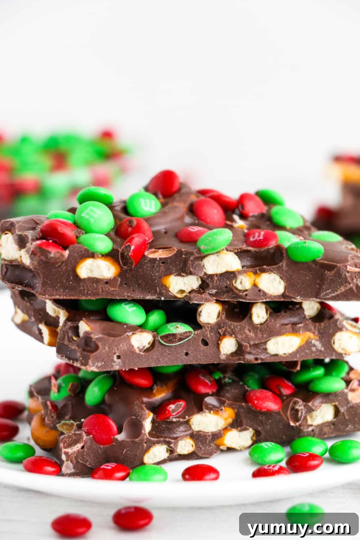 Festive Pretzel Bark 13 Stacked pieces of M&M chocolate pretzel bark, showing off the varying textures and festive colors.