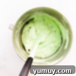 No-Churn Mint Chip Bliss 7 A gentle folding process combining mint ice cream base with a generous scattering of chocolate chips, creating a classic dessert.