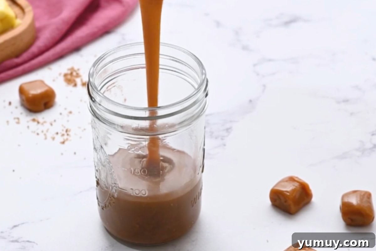 Finished brown sugar caramel sauce in a jar, cooling on a counter.