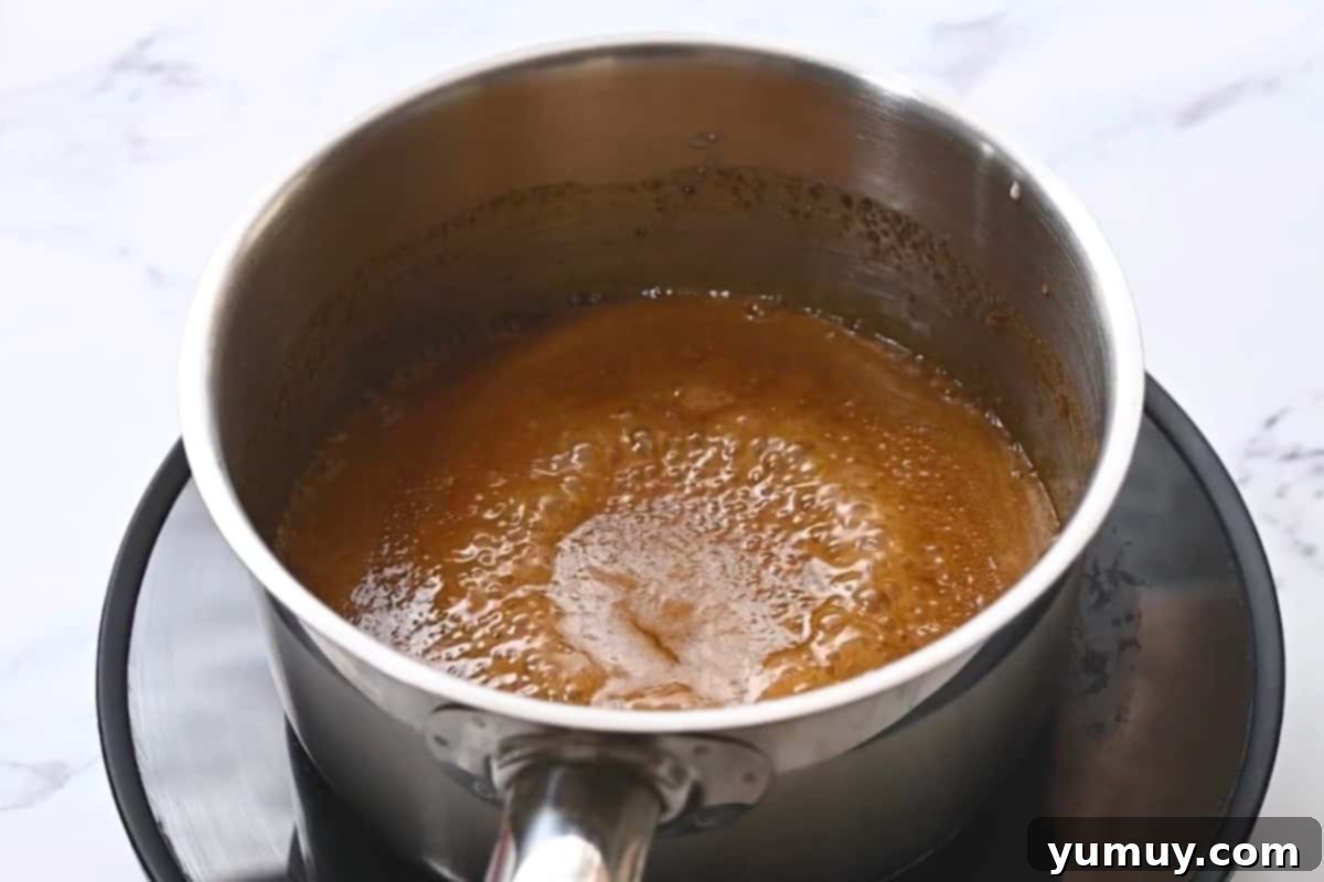 Brown sugar caramel simmering and boiling in a saucepan.