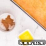 Separate small bowls holding melted butter and a finely mixed cinnamon-sugar topping.