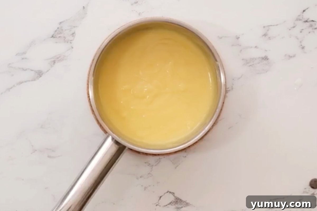 The pastry cream actively cooking on the stove, thickening to its ideal consistency.
