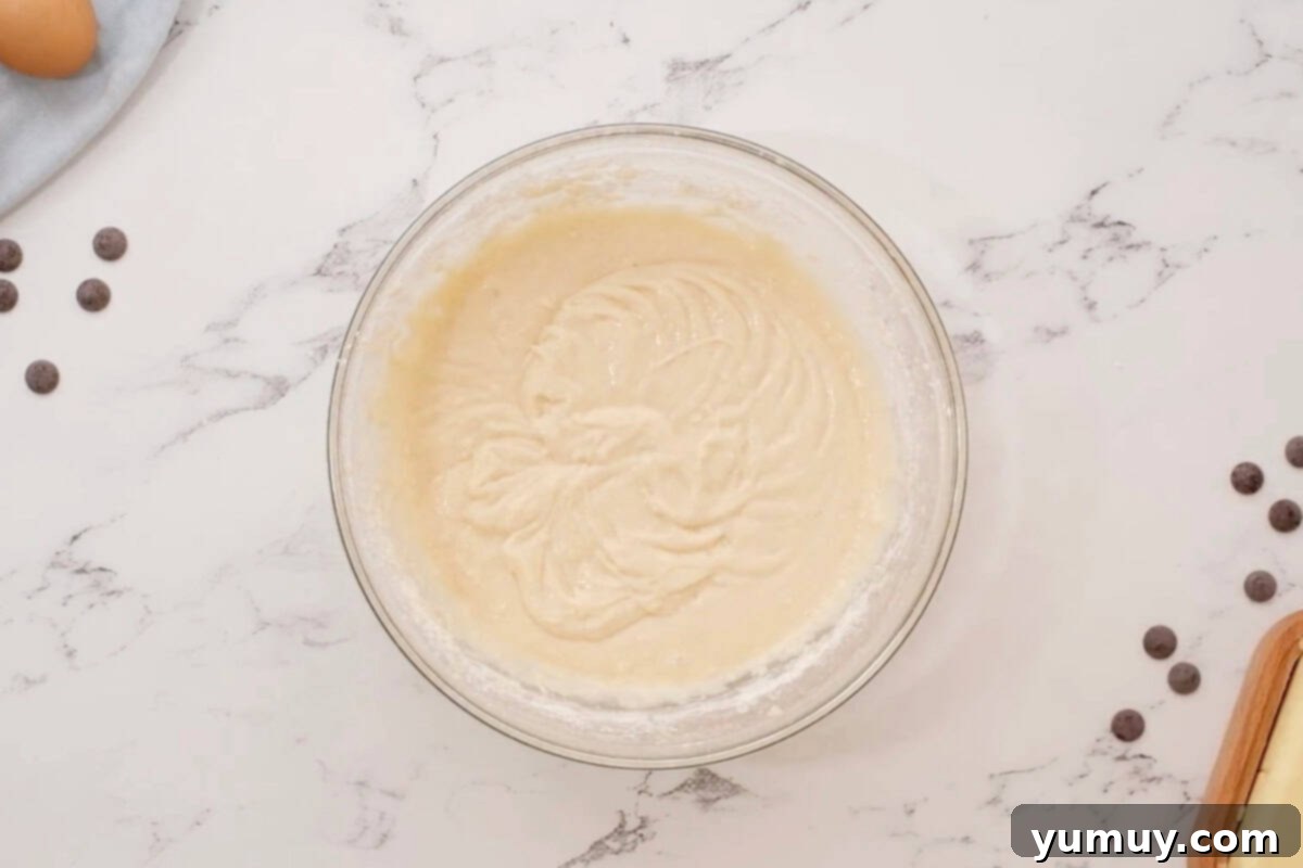 Smooth cupcake batter in a glass bowl, ready to be poured into liners.
