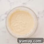 Cupcake batter being whisked together in a glass bowl, ready for baking.