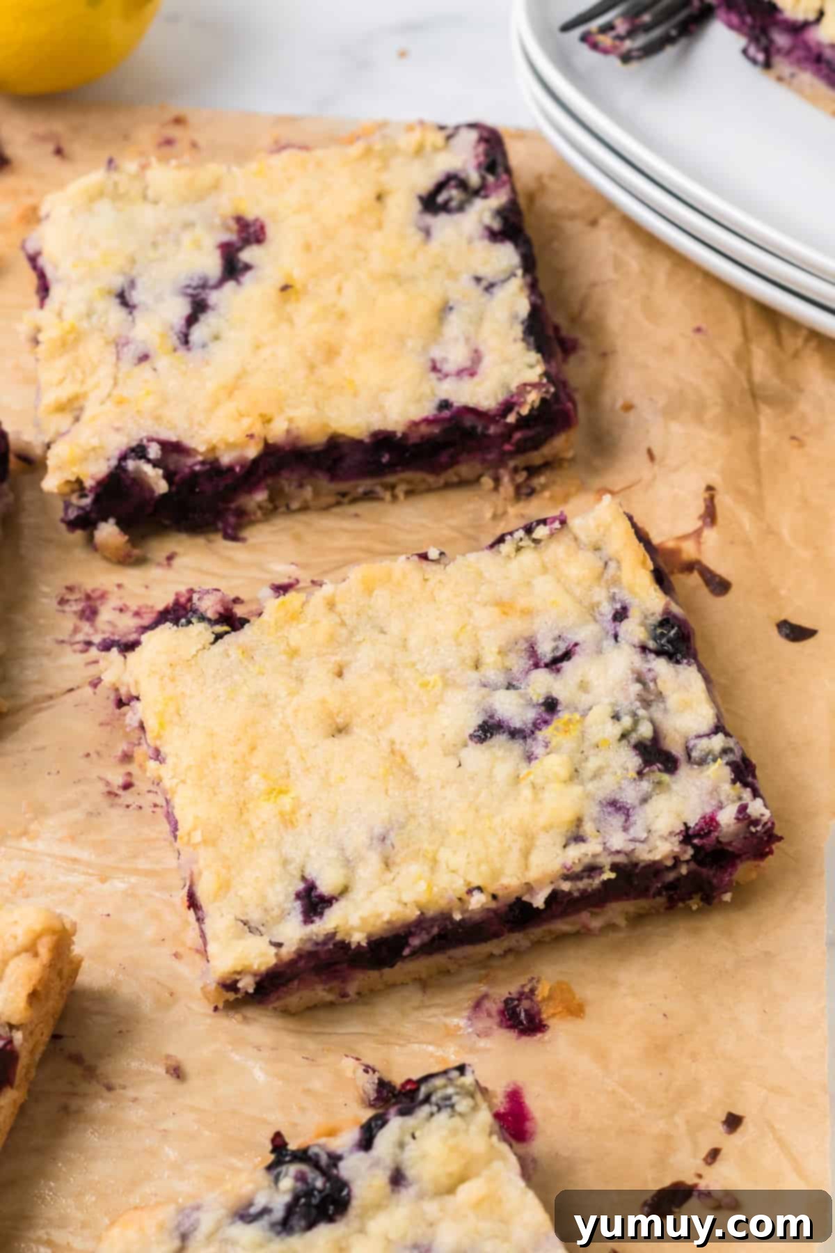 Blueberry Bliss Bars 3 sliced blueberry pie bars on parchment