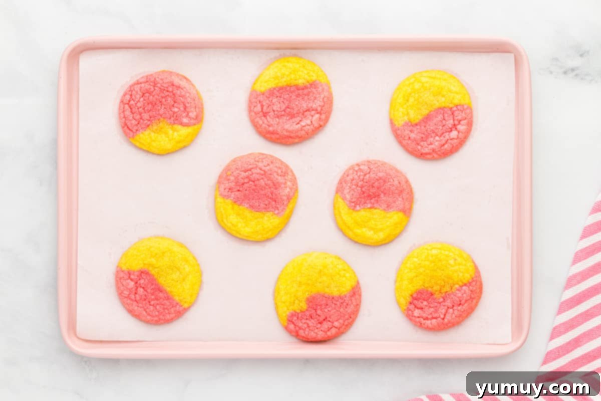 A tray of freshly baked strawberry lemonade cookies, showcasing their vibrant pink and yellow swirls.