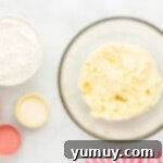 Dry flour mixture being added to the wet ingredients in a mixing bowl.