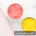 Two separate bowls of cookie dough, one pink and strawberry-flavored, the other yellow and lemon-flavored.