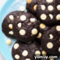 Up close view of a stack of rich chocolate cookies with melted white chocolate chips