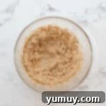 Creamed butter with brown and white sugar in a glass mixing bowl.