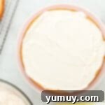 Vibrant Strawberry Lemon Cake 12 a single layer of cake with white frosting on top on a cake stand.