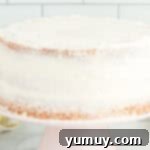 Vibrant Strawberry Lemon Cake 13 side view of a crumb-coated cake on a cake stand.