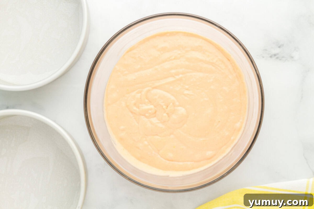Vibrant Strawberry Lemon Cake 18 peach colored cake batter in a glass bowl.