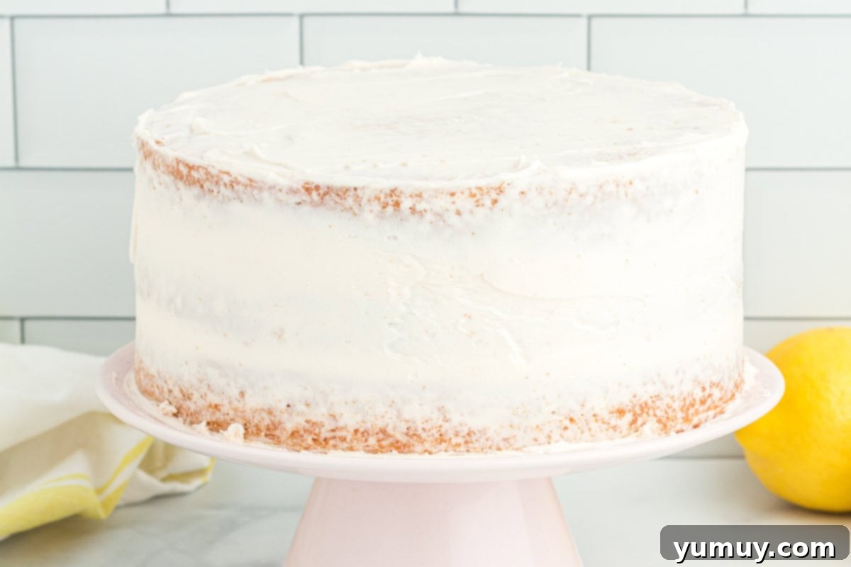 Vibrant Strawberry Lemon Cake 23 side view of a crumb-coated cake on a cake stand.