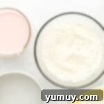 Vibrant Strawberry Lemon Cake 6 dry cake mix in a glass bowl next to a bowl of pink liquid.