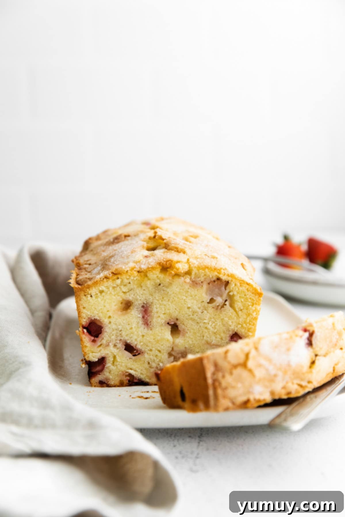 cross-section of strawberry rhubarb cake on a cake plate.