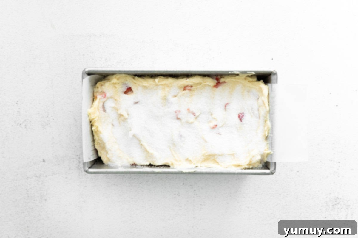 cake batter topped with sugar in a loaf pan.