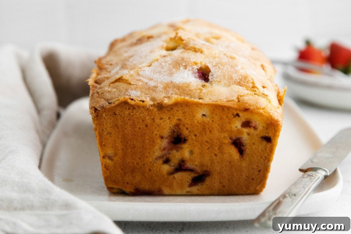 side view of strawberry rhubarb cake on a rectangular cake plate.
